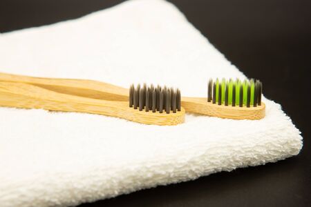 Bamboo toothbrushes with a white towel on a black background. Biodegradable natural bamboo toothbrush. Eco-friendly, zero waste, dental care No plasticの写真素材