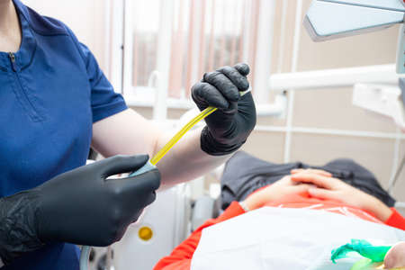 Dental assistant helping with saliva ejector during dentist treatmentの写真素材