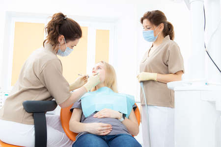 pregnant woman at the dentists office, checkup and dental treatment for pregnant women.の写真素材