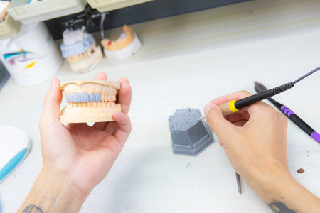 Dental technician dentist man working with dentures in a laboratory with wax on a jaw model
