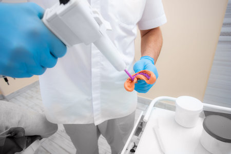 Dentist prepares material for a mold of teeth. Close-up of a dentist in blue glovesの写真素材