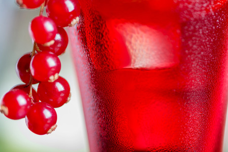 close-up of water droplets on a glasses with alcohol cocktail with cranberry juice on a table in a restaurant with a creative composition and decoration of pieces of orange and fresh berries. soft focusの写真素材