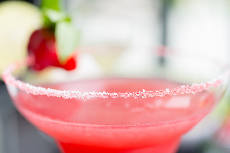 close up details of strawberry daiquiri on a table in a restaurant with creative decoration of salt on the edge of the glass with fresh mint and berries. soft focusの写真素材