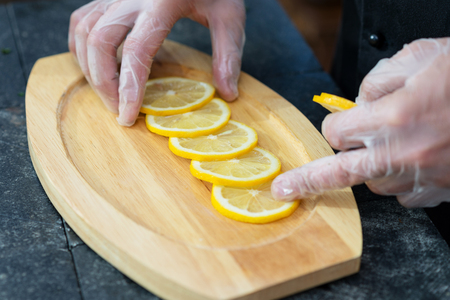 stages of cooking salmon on the grill - chef decorates a wooden platter for serving filetの写真素材