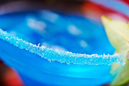 extremely close up of  bright refreshing cocktails: blue margarita on a table in a restaurant with creative decoration of salt on the edge of the glass with fruit slices and berries. soft focusの写真素材