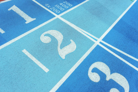 Red treadmill of special materials in the stadium with numbers starting position. Finishing or...