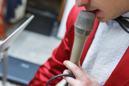 Young male entertainer prepared for the beginning of the event. Leading the event will test and configure his microphone.の写真素材