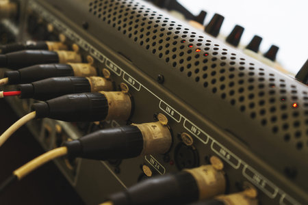 Music equipment closeup. Management console sound design at the event. Big black mixer with control knobs. Audio cable connected to the rear panel of high-quality audio equipment, an amplifier or mixer.の写真素材