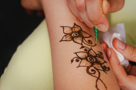 The process of applying to the skin ornament painted with henna. Hand master drawings on the body.の写真素材