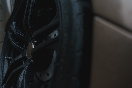 Stylish and expensive sports car closeup. Raindrops on a beautiful brown car. Black stylish sportcar alloy wheels with sports tires closeupの写真素材