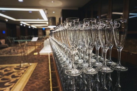 Clean transparent glasses of champagne cooked catering service for events and celebrations. Some of the hundreds of glasses for beverages prepared bartender. Soft focus and beautiful bokeh.の写真素材