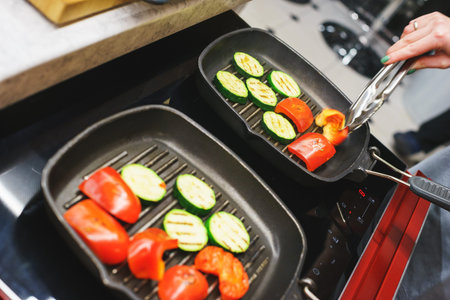 The process of cooking vegetables on the grill. Tomatoes, aubergine, zucchini baked in a special...