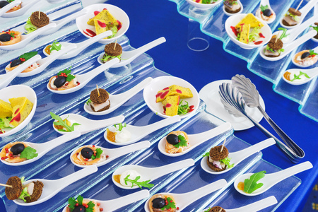Catering services during events and holidays. Light snacks and canaps, seafood, shrimp, olives on Japanese spoons for miso soup. Soft selective focus and beautiful bokeh.の写真素材