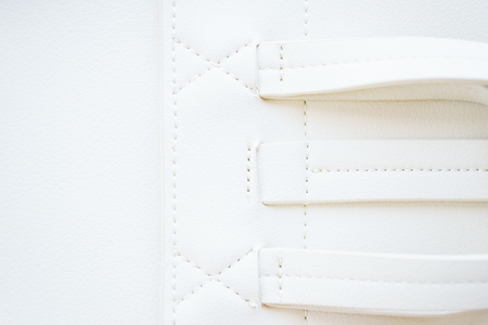 White leather and details of seams close-up. Things made of leather, texture and details of the product. Macro shooting texture and seams leather bag. Soft focus, beautiful bokeh.の写真素材