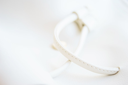 White leather and details of seams close-up. Things made of leather, texture and details of the product. Macro shooting texture and seams leather bag. Soft focus, beautiful bokeh.の写真素材