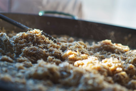 Freshly prepared juicy traditional Bavarian cabbage in a large frying pan during the octoberfest season. Soft focus and backlight.の写真素材