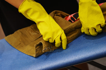 The aging process of a denim jacket, the master in rubber gloves treated the jacket with a...