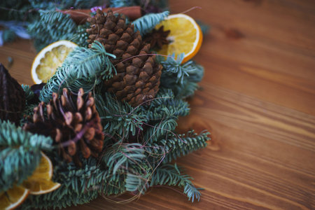 Christmas wreath of spruce branches handmade adorned with cones, dried fruit and oranges for the New...