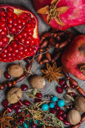 Juicy aromatic pomegranate on the table with a decor of national ornaments. Soft focus and beautiful bokeh.の写真素材