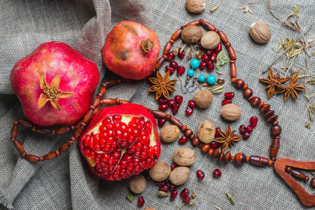 Juicy aromatic pomegranate on the table with a decor of national ornaments. Soft focus and beautiful...