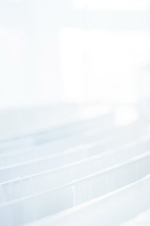 White clothes and bed linens in the dryer. Clothing and personal items after washing. Household and cleanliness. Soft focus and beautiful bokeh.の写真素材