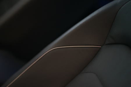 Interior details of a modern car close-up. Stylish beautiful black seats in the car. Car design and interior decoration close-up. Soft focus and beautiful bokeh, little depth of field.の写真素材