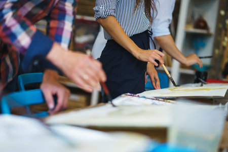 Artist makes the brush strokes on a canvas while painting a watercolor. Pupils in art school paint...