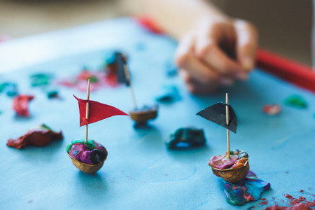 Small child sculpts from plasticine during classes with parents. Sculpting of colorful pieces of clay. The development of fine motor skills and playing with the child is a top view. Soft focus.の写真素材