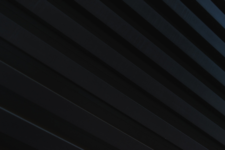 Dark stylish abstract background of wooden boards painted in black color. Natural background. Soft focus and shallow depth of field.の写真素材