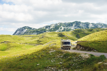 Euro-trip. Old stylish classic motorhome on the road in the mountains. Travel in the summer of Montenegro by car. National Park Durmitor.の写真素材