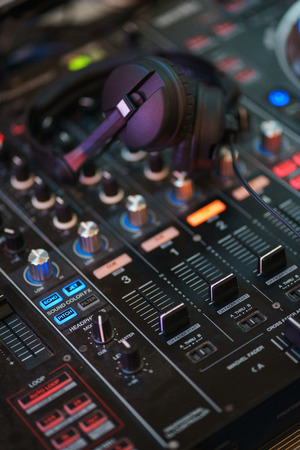 DJ equipment. Player and mixing console with headphones. Night club, music and DJ performance. Nightlife, learning concept. Soft focus and beautiful bokeh.の写真素材