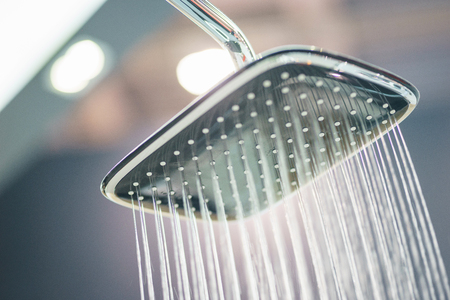 Water pours from the modern shower. Jets of water in the shower close-up. Stylish and luxury plumbing. Water saving and refreshing shower.の写真素材