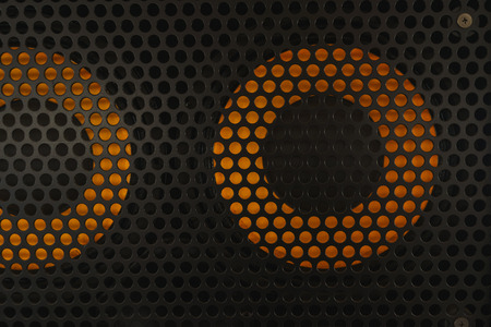 Protective decorative metal grill with honeycombs on modern acoustic systems. Music speakers close-up. Abstract background closeup, soft focus and beautiful bokeh.の写真素材