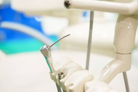 Dental equipment at the clinic close-up. Medical instruments for examining and treating patients. Dentistry and dental treatment. Dental chair, details. Tubes, lamps, accessories, tool table close-up.の写真素材