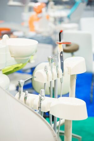 Dental equipment at the clinic close-up. Medical instruments for examining and treating patients. Dentistry and dental treatment. Dental chair, details. Tubes, lamps, accessories, tool table close-up.の写真素材