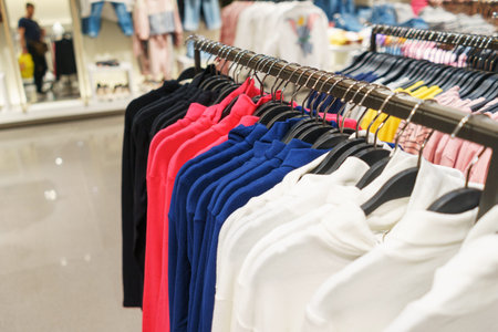 Modern fashion store. Buyers choose clothes. Shirts, hoodies, blouses and half-sweaters, a sweater...