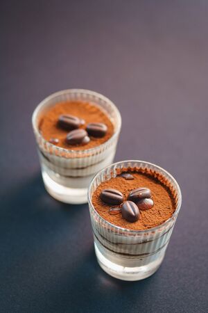 Traditional tiramisu dessert in a glass goblet on the table. Catering and refreshments for guests and participants of the event.の写真素材