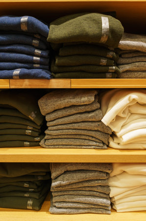 Modern fashion store. Buyers choose clothes. Fashionable men's and women's clothes on hangers in a...