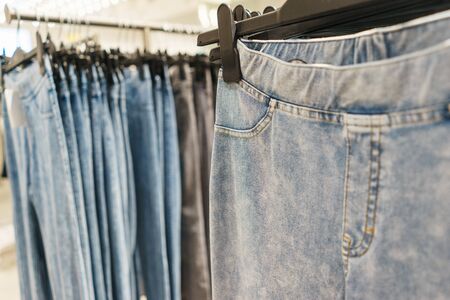 Modern fashion store. Buyers choose clothes. Fashionable men's and women's clothes on hangers in a clothing store. Sale and shopping in stores. Soft focus.の写真素材