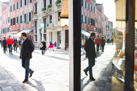 VENICE, ITALY - OCTOBER, 2019. Travelers on the narrow historical streets of the ancient city. Trip to Italy. Bright sunny day on the streets. Streets and canals in Venice.のeditorial素材