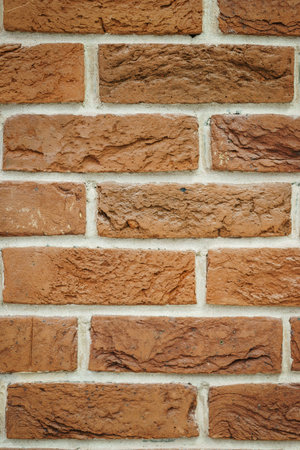 Red brick wall closeup. Abstract background. Brickwork and glue, gray seams between bricks. Style...