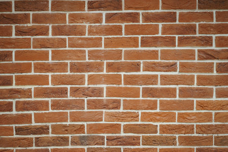 Red brick wall closeup. Abstract background. Brickwork and glue, gray seams between bricks. Style...