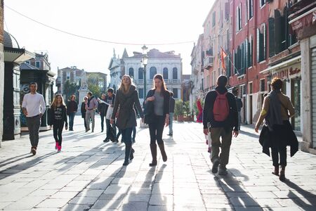 VENICE, ITALY - OCTOBER, 2019. Travelers on the narrow historical streets of the ancient city. Trip to Italy. Bright sunny day on the streets. Streets and canals in Venice.のeditorial素材