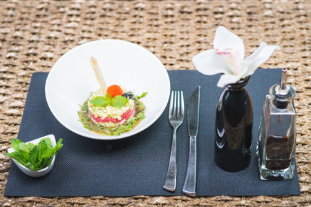 Classic traditional tartar salad laid in a round shape, stylish serving in an oriental style table...