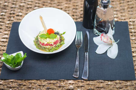 Classic traditional tartar salad laid in a round shape, stylish serving in an oriental style table in a restaurant.の写真素材