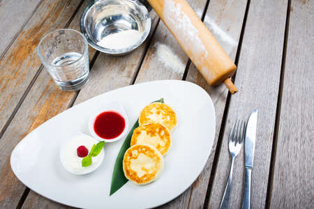 Traditional breakfast with coffee and cheesecakes, cottage cheese pancakes on a plate with syrup and jam.の写真素材