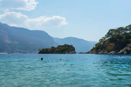 Vacationers and families children swim in lagoon. Sunbathing on sunbeds umbrellas. Editorial.の写真素材