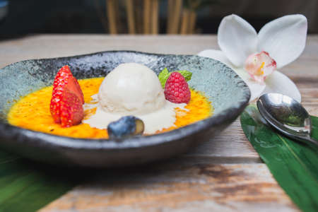 Traditional dessert cream catalana and creme brulee in a beautiful plate on a wooden table in a restaurant or cafe.の写真素材