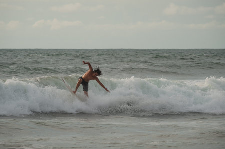 BALI, INDONESIA-MARCH 2020: Young people ride on short boards, perform tricks on the waves. Extreme...