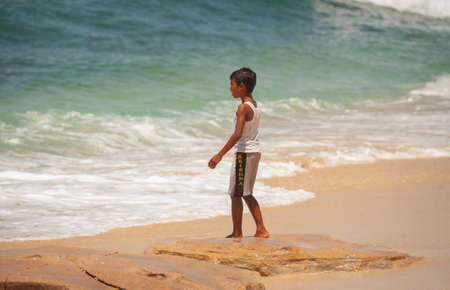 BALANGAN Beach, BALI, INDONESIA-SPRING, 2020: Vacationing young people are sunbathing sandy beach. Travel and beach holidays on a tropical island. Families children and people on beach by cliff.のeditorial素材